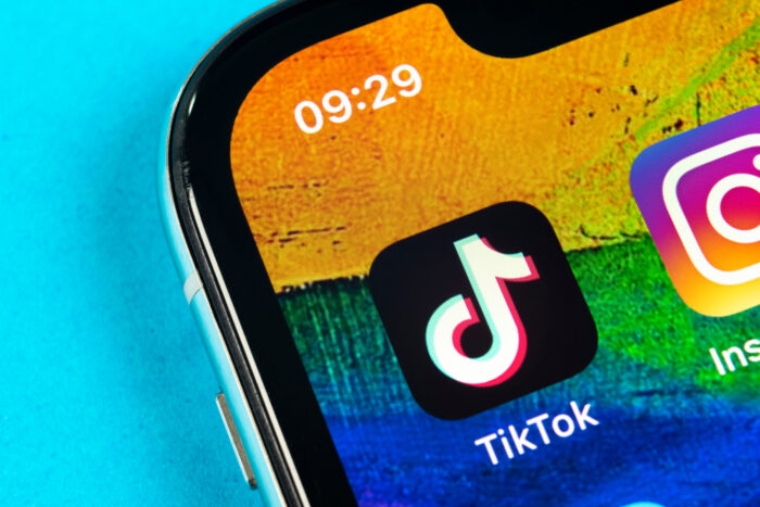 Tik Tok application icon on Apple iPhone X screen close-up.