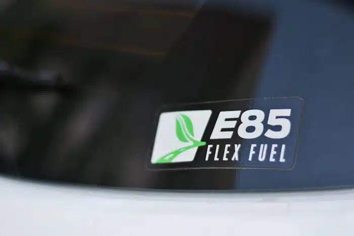 Soft focus image of sticker with logo and wording “E85 FLEX FUEL" stick at rear glass of a car.