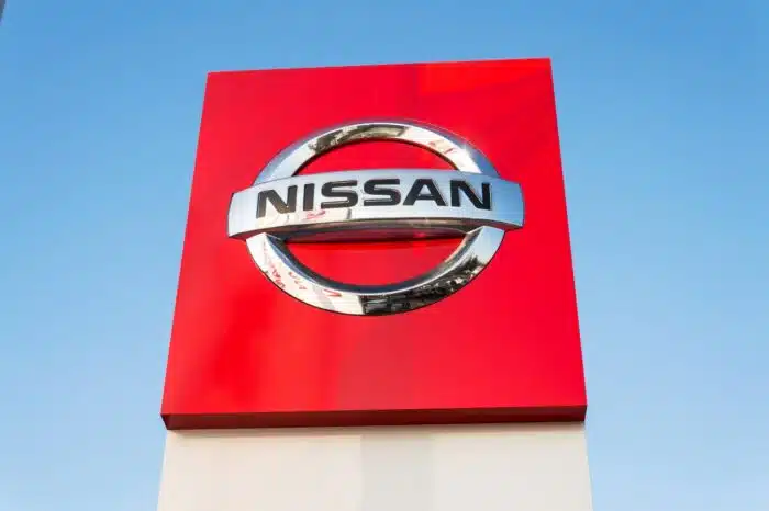 Nissan motor company logo in front of dealership building
