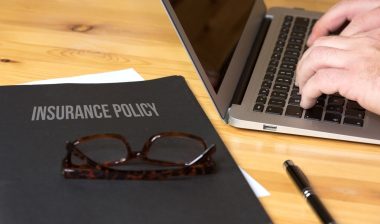 computer and a folder with insurance policy, insurance settlement