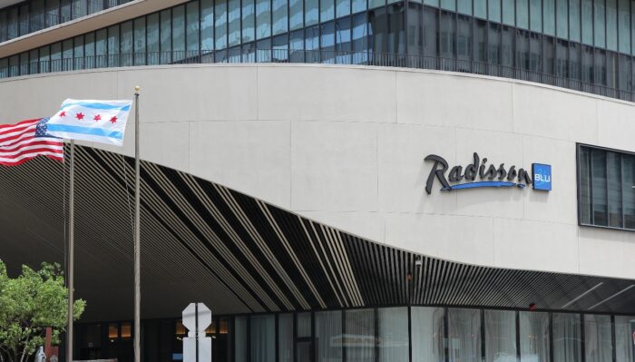 People walk past Radisson Blu hotel