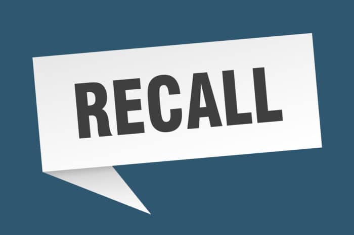 Recall speech bubble sign against a dark blue background.