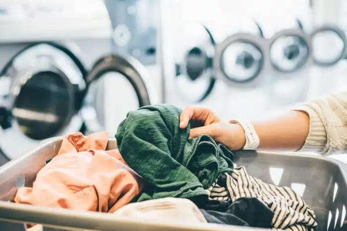 interior of small laundromat in daylight. Close-up female holding basket - hercules laundry card, hercules class action
