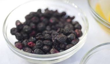 Freeze dried blueberries in a bowl on a white background.