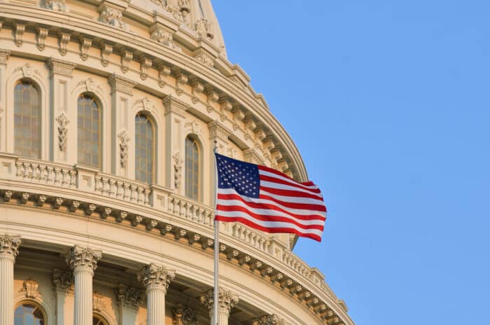 The U.S. Capitol building dome detail and waving American flag - baby formula shortage, U.S. House of Representatives