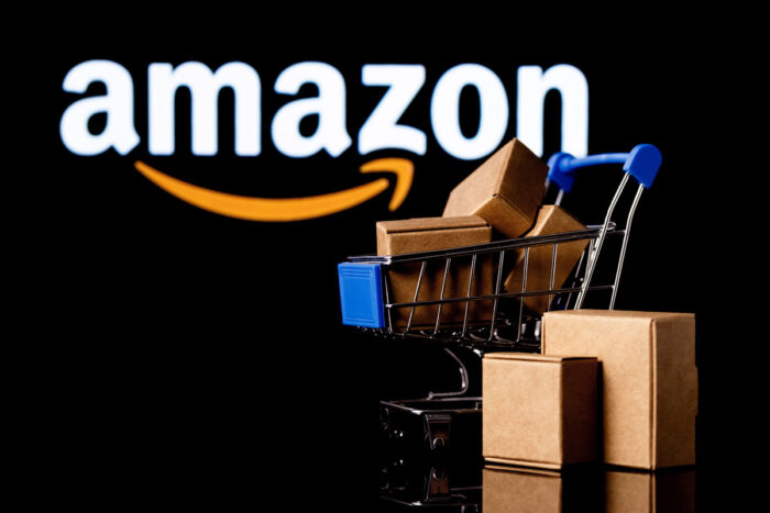 Shopping cart with parcels on the black background with Amazon logo.