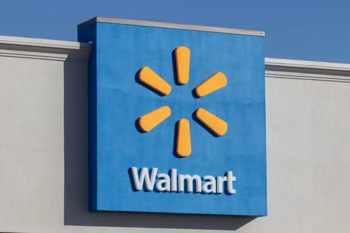 Close up of exterior Walmart signage against a blue sky.