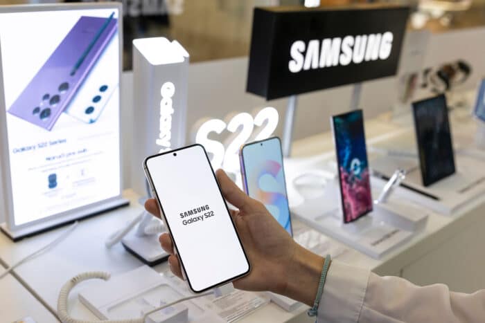 New Samsung Galaxy S22 mobile smartphone is shown in hand in electronic store.