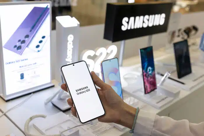 New Samsung Galaxy S22 mobile smartphone is shown in hand in electronic store.