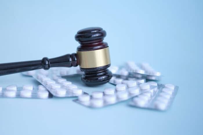 Gavel and pills on a blue background.