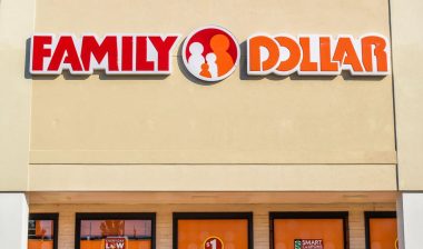 Closeup of "Family Dollar" discount store chain's exterior facade brand and logo signage in red and orange letters on a sunny day.