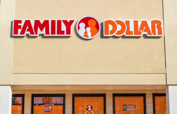 Close up of "family dollars" discount store chain exterior facade branding and logo in red and orange lettering on a sunny day.