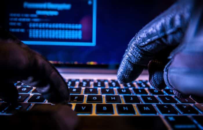 Hacker in Black Gloves Hacking the System. health care data breaches