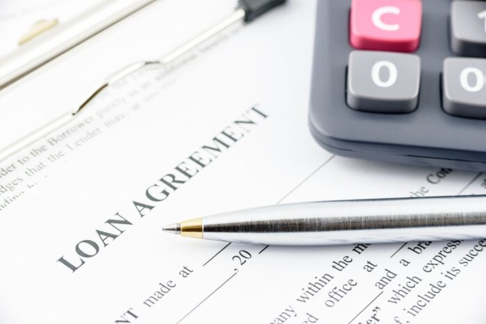 Blue ballpoint pen and a calculator on a loan agreement - tribal loans, silver cloud financial lawsuit
