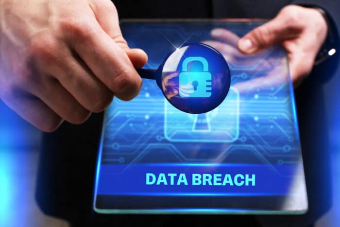 Young businessman working on a virtual screen of the future and sees the inscription: Data breach.