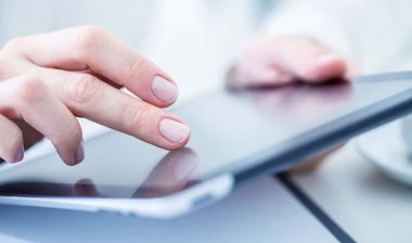 Close-up of female hands touching digital tablet.