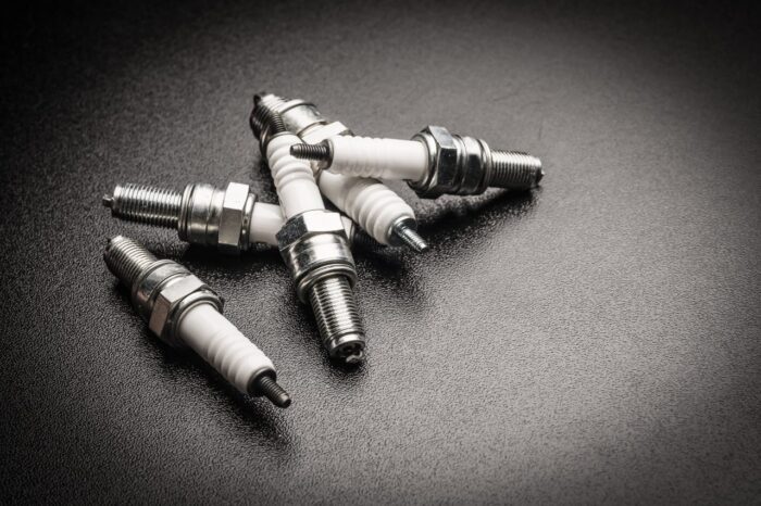 Spark plugs on black background - price, oxygen sensors, price-fixing settlement