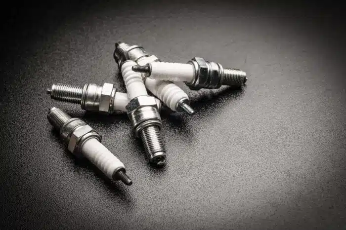 Spark plugs on black background - price, oxygen sensors, price-fixing settlement