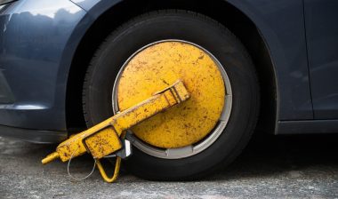 Car wheel blocked by wheel lock, boot man