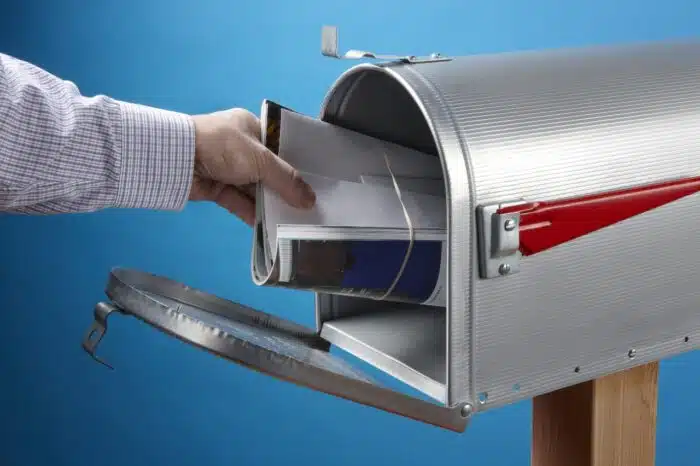 Man takes out mail at an open mailbox