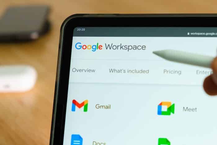 Google Workspace logo shown by apple pencil on the iPad Pro tablet screen. Man using application on the tablet - class action