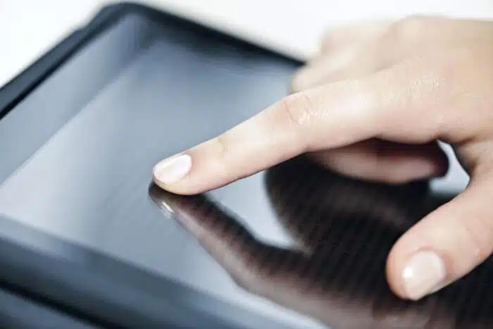 Female hand touching tablet computer screen with finger.
