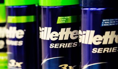 Close up of various Gillette shaving cream bottles on a supermarket shelf.