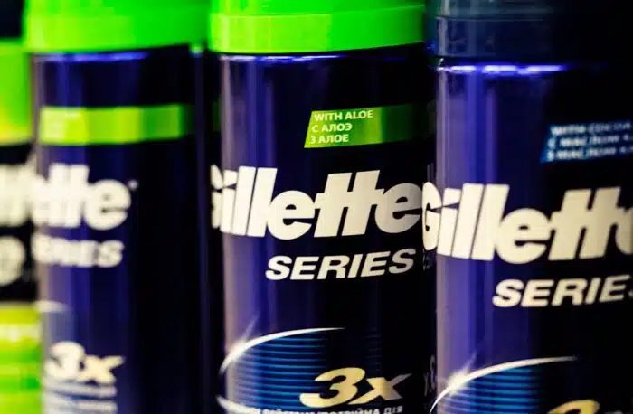 Close up of various Gillette shaving cream bottles on a supermarket shelf.