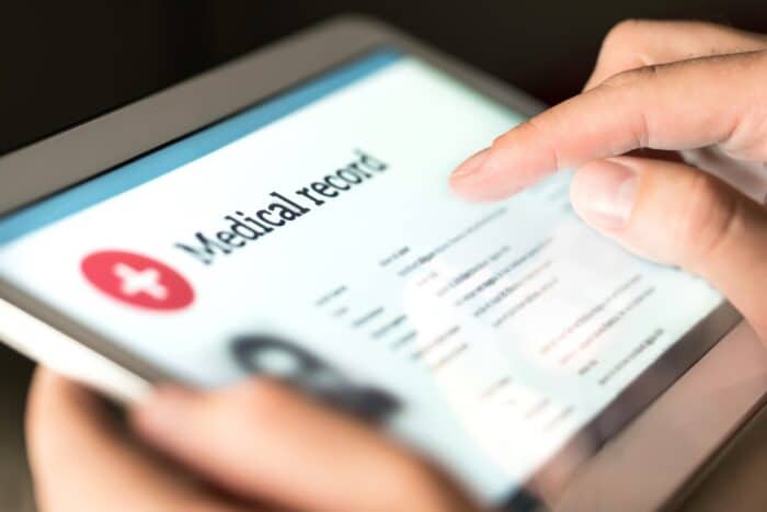 Electronic medical record with patient data and health care information in tablet. Ciox Health lawsuit settles medical record fees