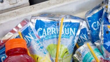 Several pouches of Capri Sun fruit drinks in an ice cooler.