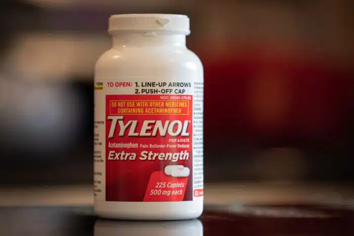 Bottle of Adult Tylenol Extra Strength with a blurry background.