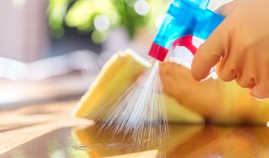 Cleaning with spray detergent, rubber gloves and dish cloth on work surface