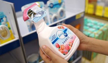 Female hand holding the new Febreze fabric freshener spray bottles.