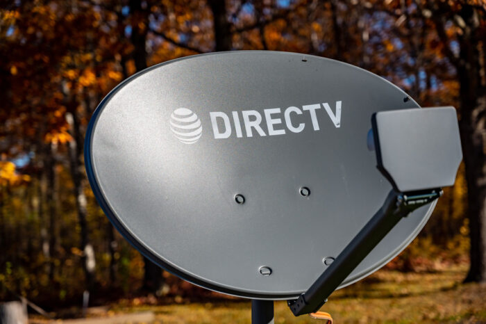Directv satellite dish with autumn leaves in the background.