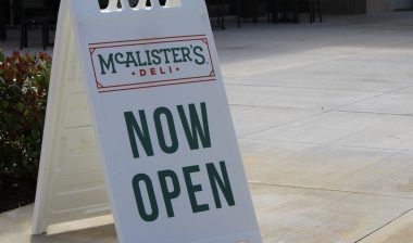 Now Open sign of McAlister's Deli. Restaurant and Sandwich Shop and famous sweet tea.