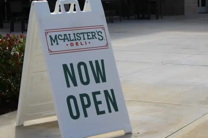 Now Open sign of McAlister's Deli. Restaurant and Sandwich Shop and famous sweet tea.