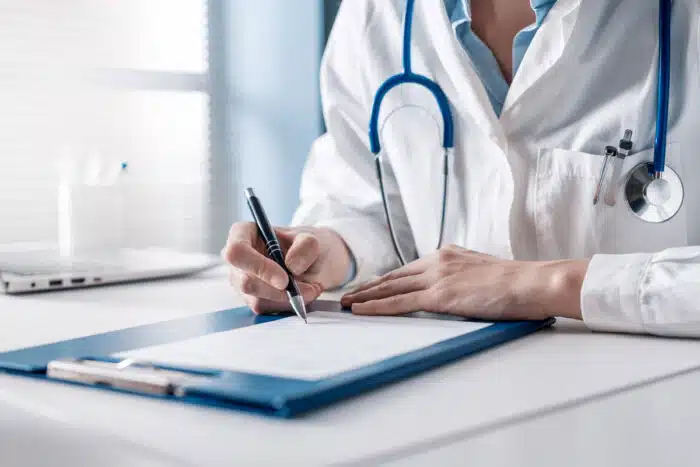 Close up of a doctor signing a piece of paper. Telehealth contract concept - rvu emergency medicine, teamhealth lawsuit