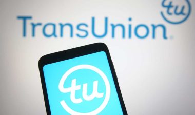 TransUnion Holding Company, Inc logo displayed on a mobile phone and a computer screen.