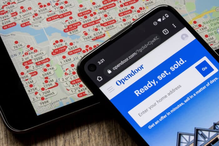 The homepage of Opendoor is seen on a smartphone against Zillow's map page on an iPad.