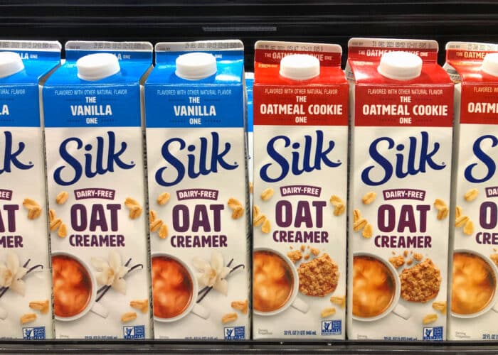Grocery store shelf with cartons of Silk brand Dairy Free Oat creamers.