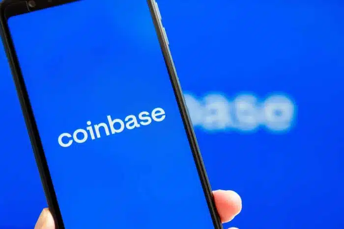 Coinbase mobile app running at smartphone screen with Coinbase logo at background - Coinbase class action, account hacks