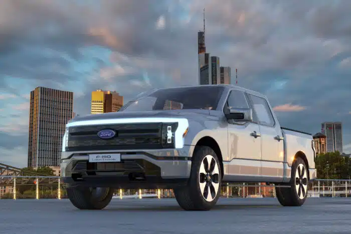 Photo of Ford F-150 Lightning against a city background.