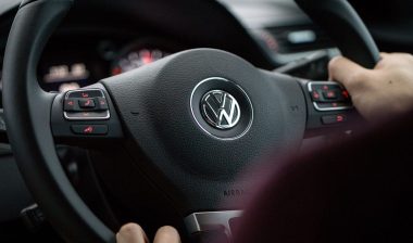 Close up of a Volkswagen emblem on a steering wheel.