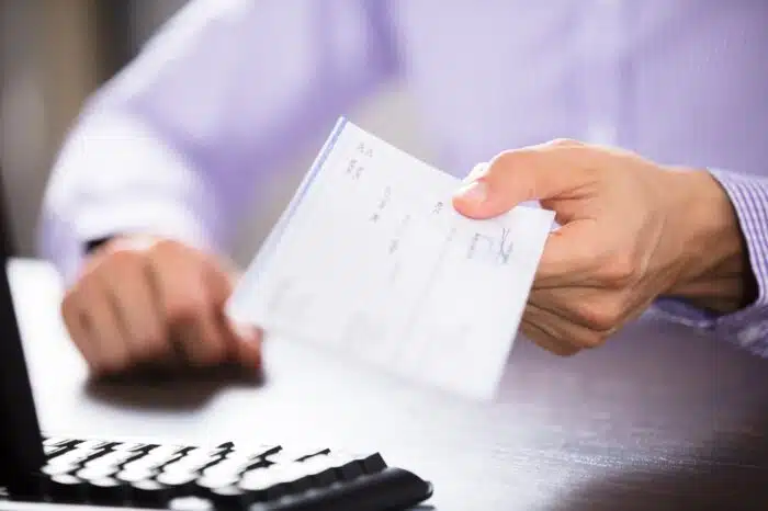 Close-up of a business person's hand handing over a check in an office -  NorthBay Healthcare, health care workers settlement
