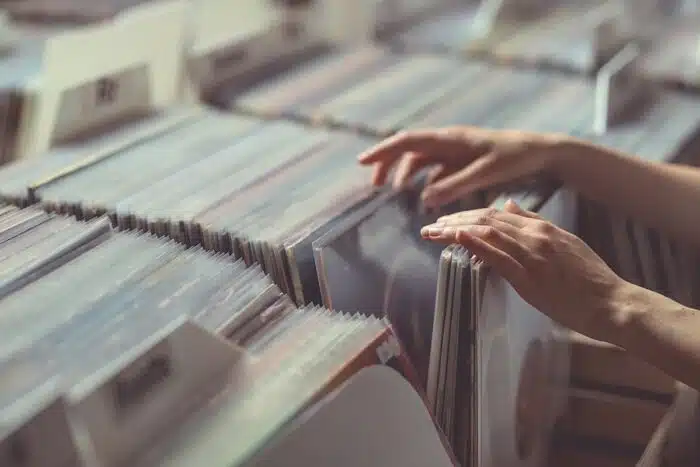 A pair of hands browse records in a vinyl record store, representing the Audiophile Music Direct and Mobile Fidelity Sound Lab class action.