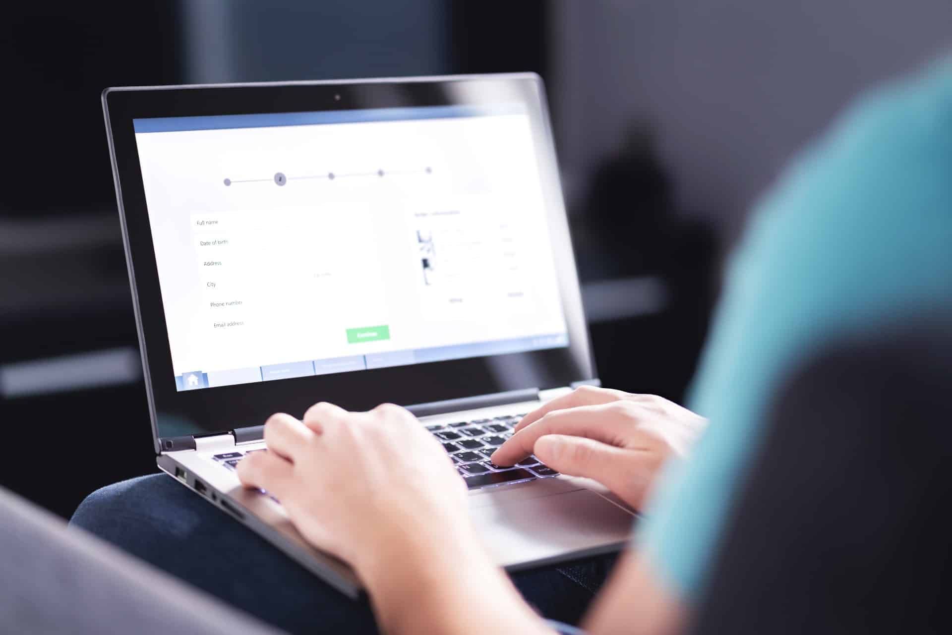 A person using a laptop fills out an online form - settlements closing