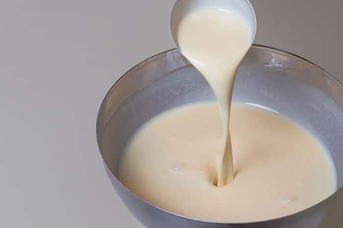 Close up of pancake mix in a bowl on white tabletop.