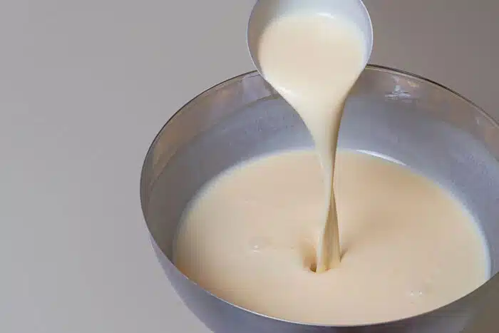 Close up of pancake mix in a bowl on white tabletop.