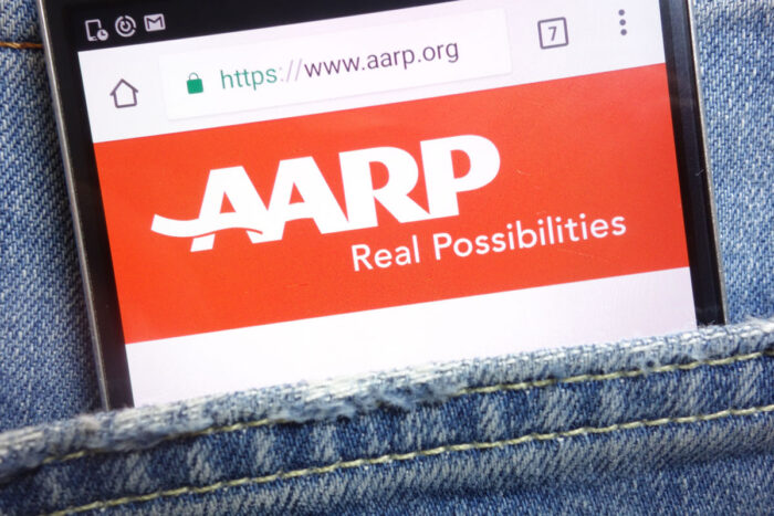 AARP (American Association of Retired Persons) website displayed on smartphone hidden in jeans pocket.