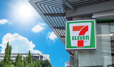 Close up of 7 Eleven signage against a blue sky.